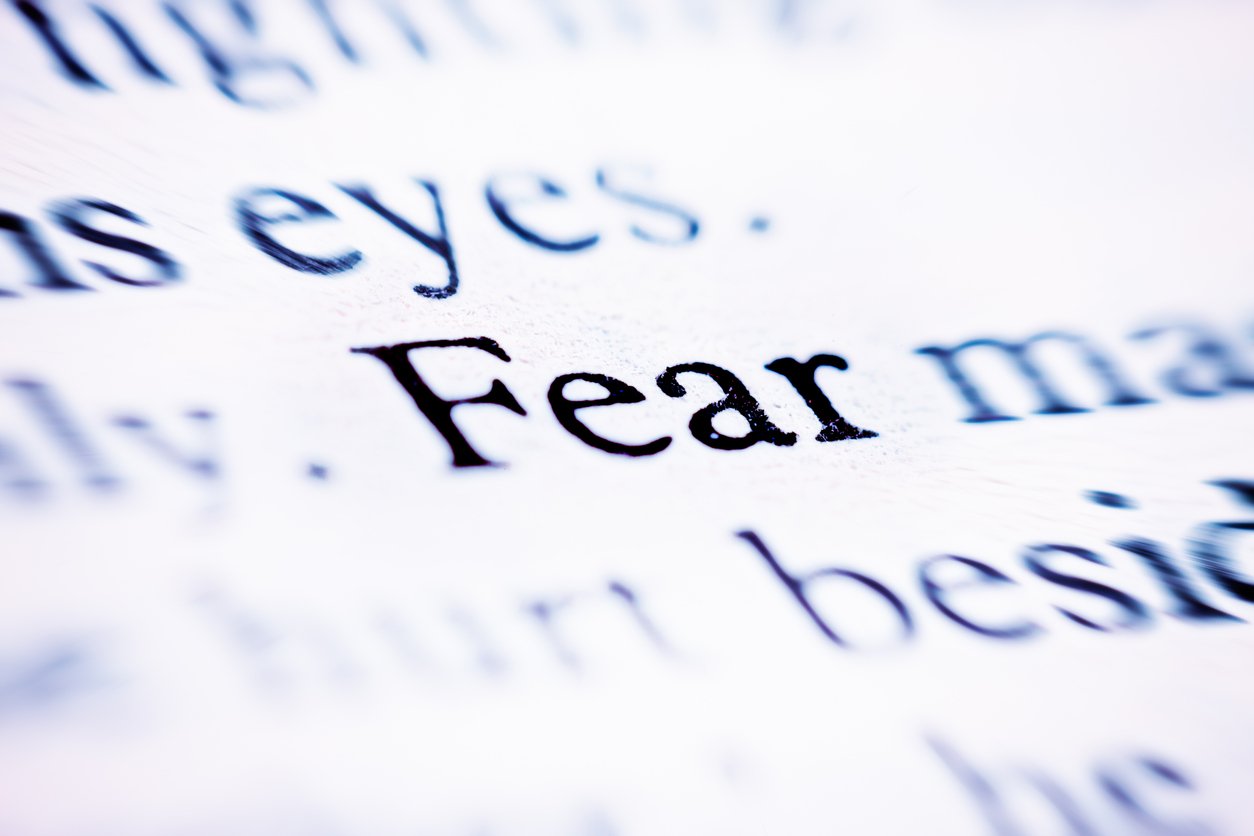 The word "Fear" stands out on a printed page otherwise defocused.